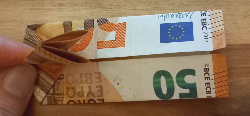 Geldschein, der oben festgehalten wird.