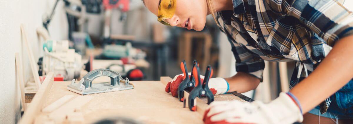 Handwerkerin, die etwas abmisst.