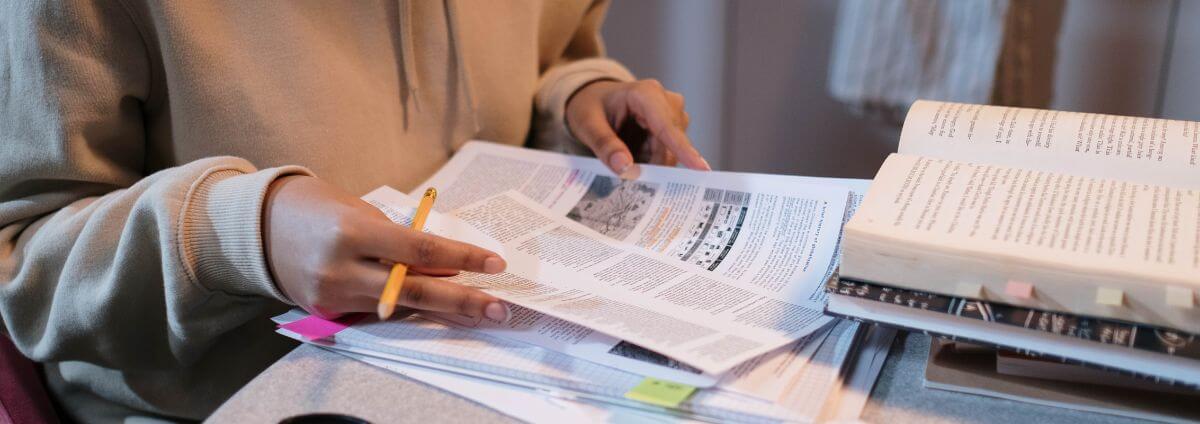 Junge Frau, die Bücher und Texte studiert.