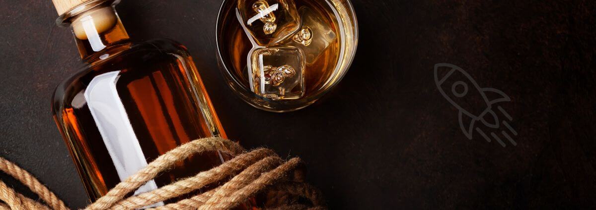 Eine Flasche Rum, um die eine Kordel gewickelt ist und ein Tumbler.