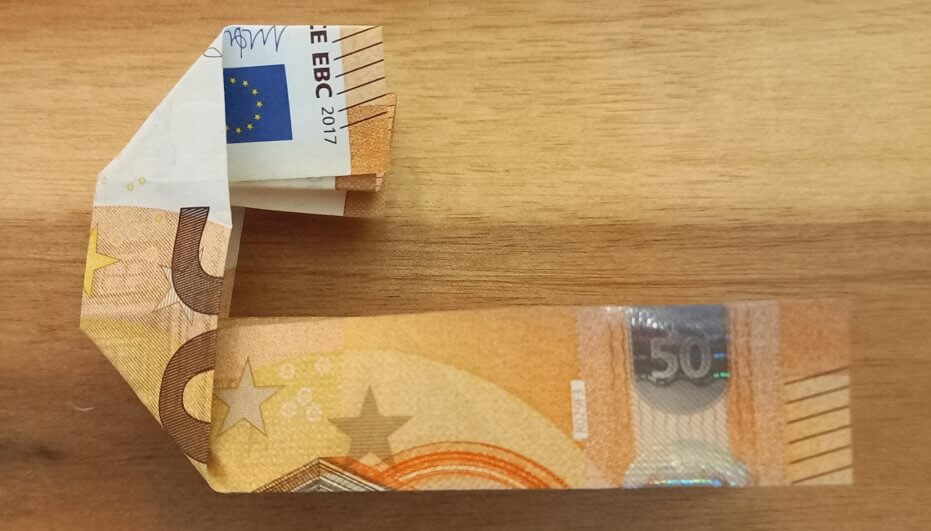 Geldschein, der wie ein liegendes J aussieht