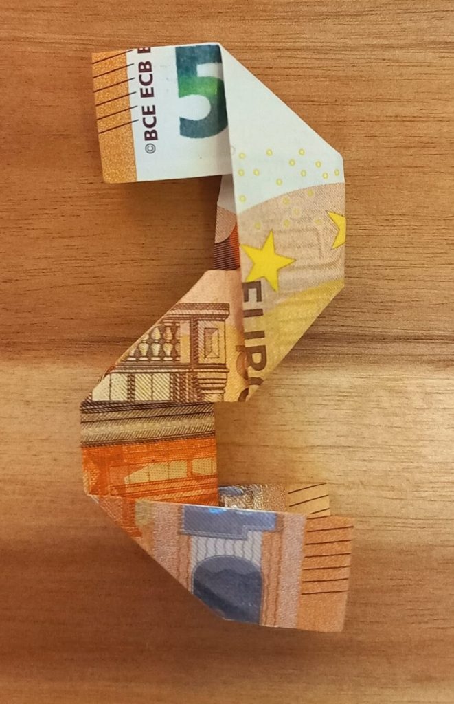 Zahl 2, die aus einem Geldschein gefaltet wurde.