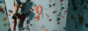 Mann, der in einer Boulderhalle klettert.