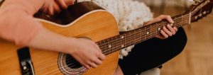 Frau, die auf einer Gitarre spielt.