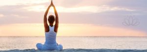 Frau, die am Strand Yoga macht.