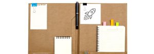 Konferenzmappe aus Leder mit einem Stift und kleinen Notizblöcken.