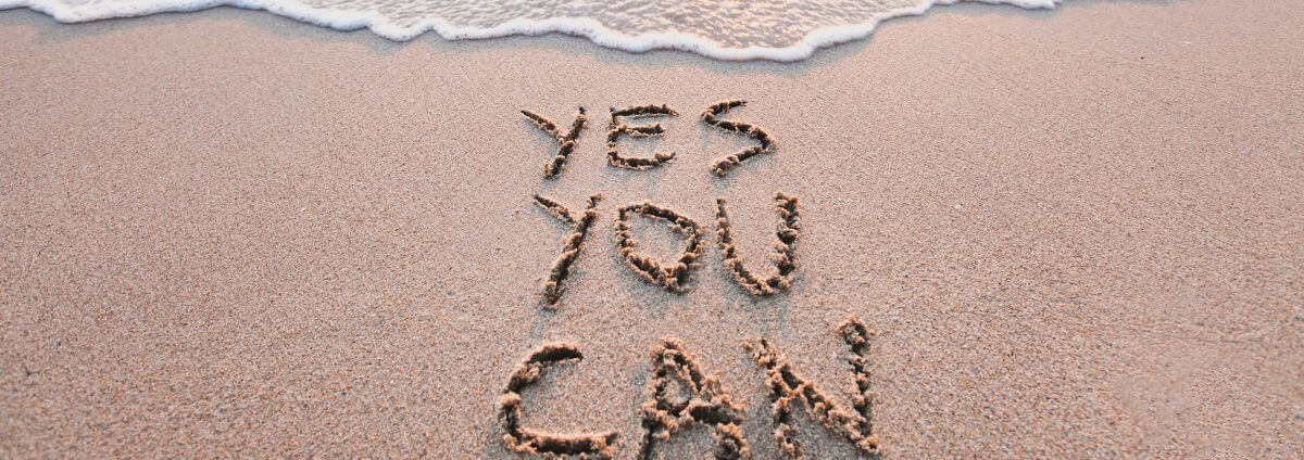 Strand, an dem "Yes you can" in den Sand geschrieben wurde.